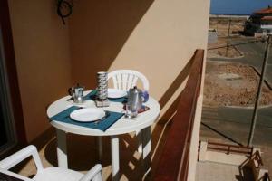 a small white table and chairs on a balcony at Casa Bahia 8 in Santa Maria