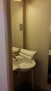 a bathroom with a sink, toilet and mirror at Hotel Bel Alp Manosque in Manosque