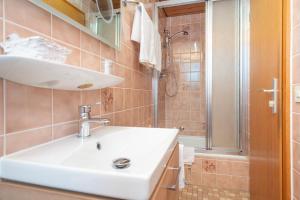 ein Bad mit einem Waschbecken und einer Dusche in der Unterkunft Gästehaus Kochelsee in Kochel