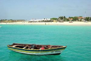 un pequeño barco en el agua cerca de una playa en Casa Bahia 8, en Santa Maria