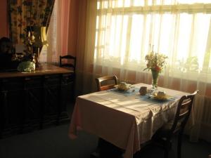 a dining room table with a white table cloth and a window at A l'abri des vents in Saint-Jean-le-Thomas