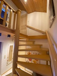 a staircase in a tiny house with wooden railings at Woidrausch´n in Philippsreut