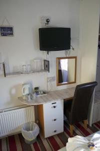 a room with a desk with a television and a chair at The Eastleigh in Skegness