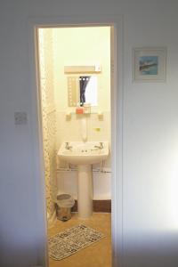a bathroom with a sink and a mirror at The Eastleigh in Skegness