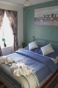 a bedroom with a blue bed with a bow on it at The Eastleigh in Skegness