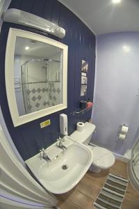 a bathroom with a sink and a toilet and a mirror at The Eastleigh in Skegness