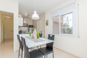 a kitchen and dining room with a white table and chairs at Casa Rilk in Sant Pere Pescador
