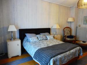 ein Schlafzimmer mit einem Bett, zwei Lampen und einem Stuhl in der Unterkunft Chambres d hôtes du Stockgarten in Betting-lès-Saint-Avold