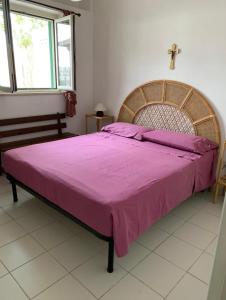 una camera da letto con un grande letto con una croce sul muro di Villa a Peschici (Puglia-Gargano) a Peschici