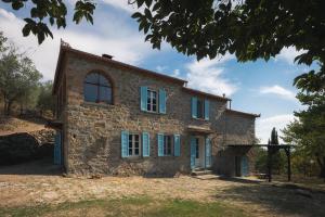an old stone house with blue shutters at Villa Pietra Viva in Lucignano