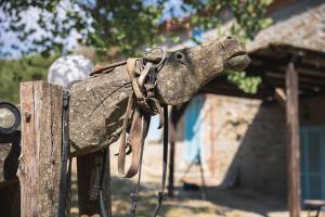 a statue of a horse attached to a wooden post at Villa Pietra Viva in Lucignano