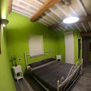 サンタンジェロ・イン・ヴァードにあるBed and Breakfast Dal Tenenteの緑の壁のベッドルーム1室、ベッド1台が備わります。
