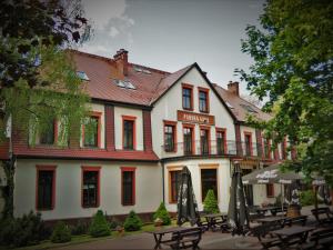 a building with tables and umbrellas in front of it at Pańska Góra in Jaworzno