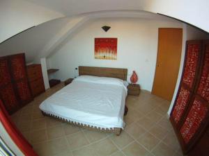 a bedroom with a white bed in an attic at Casa Bahia 10 Grande Penthouse in Santa Maria