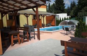 eine Terrasse mit einem Pool mit einem Tisch und Bänken in der Unterkunft Apartmán Sophia 3 in Velké Losiny