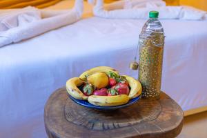 a bowl of fruit on a table next to a bottle at Riad Louaya in Marrakech