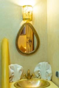 a bathroom with a sink and a mirror at Riad Louaya in Marrakesh