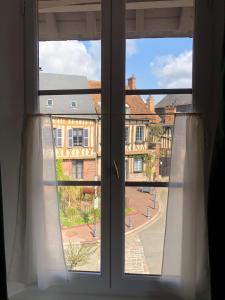 an open window with a view of a city at Centre historique de LYONS LA FORET Hotel de Maître le Cottage in Lyons-la-Forêt +9 photos