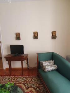sala de estar con sofá verde y mesa en Casa Jean Pineau, en Elciego