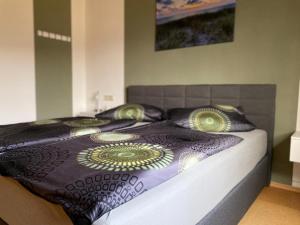 a bed with a black comforter and pillows on it at Ferienwohnung Jenny Edersee in Edersee