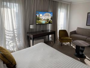 Télévision ou salle de divertissement dans l'établissement Hôtel Le Canberra