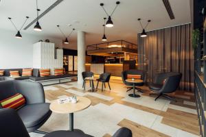 a lobby with chairs and tables and a bar at harry's home hotel & apartments in Bischofshofen