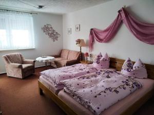 ein Schlafzimmer mit einem großen Bett mit einer lila Tagesdecke in der Unterkunft Pension Sonnenhügel in Markersdorf