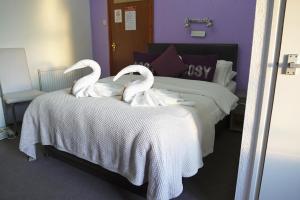 two swans sitting on top of a bed at The Eastleigh in Skegness