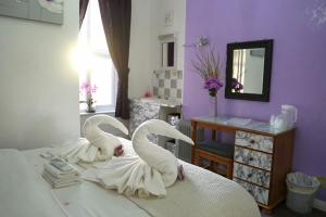 two white swans are sitting on a bed at The Eastleigh in Skegness
