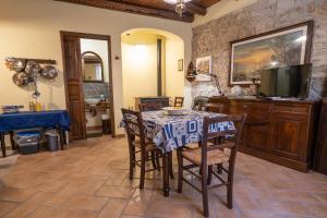 a dining room with a table and chairs and a television at Casa della Nonna in Caltavuturo