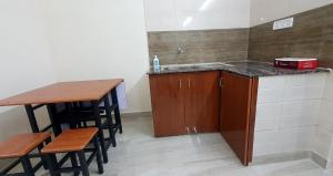 a kitchen with a sink and a counter with stools at Sunshine Stay in Chennai