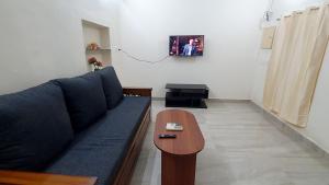 - un salon avec un canapé bleu et une table dans l'établissement Sunshine Stay, à Chennai