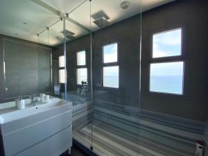 een badkamer met een glazen douche en een wastafel bij Marina Atlantic Cruise - By AppartAli in Casablanca