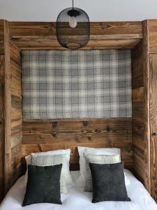 a bedroom with a wooden headboard and a bed with pillows at Ecrin des Glaciers Combloux in Combloux