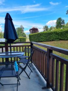 a table and a chair and an umbrella on a balcony at Ecrin des Glaciers Combloux in Combloux