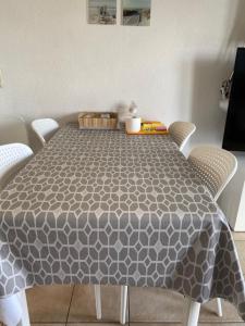 a dining room table with a gray and white table cloth at Genieten aan zee in De Haan in De Haan