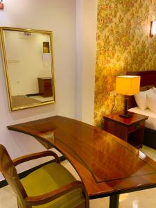 um quarto com uma secretária, um espelho e uma cama em ruwanara royal majestry em Ambagahagedara