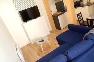 昂古萊姆的住宿－Le NOTRE DAME - HYPER CENTRE - WIFI - NETFLIX，客厅配有蓝色的沙发和桌子
