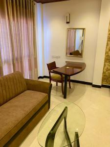 a living room with a couch and a table at ruwanara royal majestry in Ambagahagedara