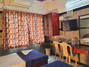 uma cozinha com mesa e cadeiras e uma janela em HOTEL GREENS - Puratchi Thalaivar Dr M G Ramachandran Central Railway Station Chennai em Chennai