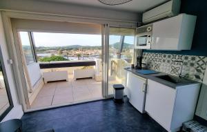 een keuken met uitzicht op een balkon bij Cyrène Port Nature 5 in Cap d'Agde +14 foto's