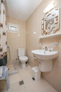 a white bathroom with a sink and a toilet at Garden Studios Thassos Town in Limenas +16 photos