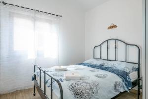 1 dormitorio con cama de metal con sábanas azules y blancas en Captain Villa 2 km to the beach, en Vintijan
