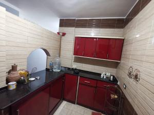 a kitchen with red cabinets and a counter top at Qussier sea view apartment in Quseir