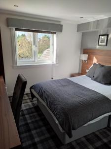 Un dormitorio con una cama grande y una ventana en Mango the Hotel, en Haggs