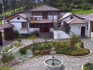 una casa con una fontana in mezzo a un giardino di Hosteria San Jose de Sigchos a Sigchos