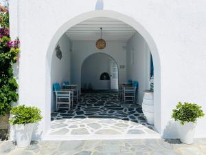 a hallway with an archway with chairs and tables at Cyclades Blue in Ornos