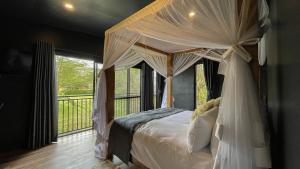 a bedroom with a canopy bed and a balcony at The Shed in Nakuru