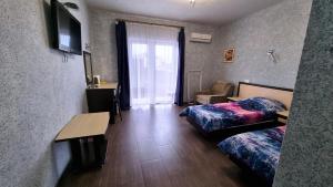 ヴィチャゼヴォにあるGostevoy Dom Korvetのベッド2台、椅子、窓が備わる客室です。