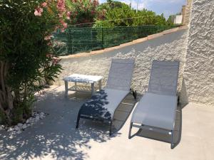 - une terrasse avec 2 chaises et une table dans l'établissement Villa ZEN, au Grau-du-Roi